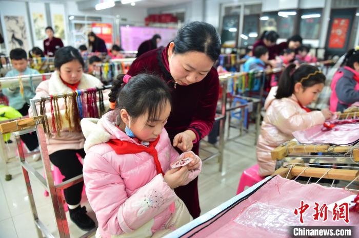 江西省級(jí)非遺豫章繡傳承人手把手指導(dǎo)小學(xué)生繡制2022年北京冬奧會(huì)吉祥物“冰墩墩”形象?！∮髟屏?攝