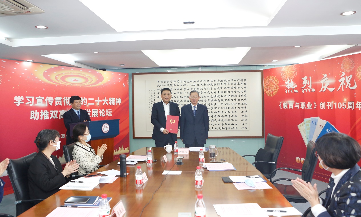 郝明金為《教育與職業(yè)》雜志編委代表陳曉明頒發(fā)聘書。中華職教社供圖