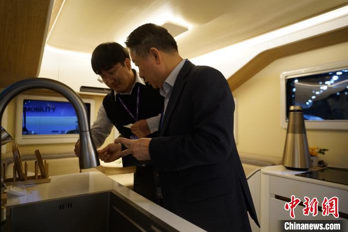 圖為參展商向觀眾介紹房車內部設計?！⑿?攝