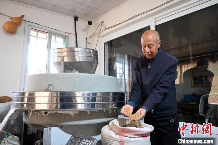 李家莊村民谷文朝重拾父輩的手藝，做起石磨面粉的營(yíng)生?！〉杂鸺?攝