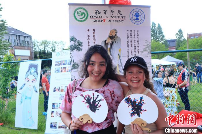 孩子們展示自己的吹墨畫團扇作品。　魯汶孔子學院供圖