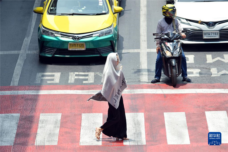 5月17日，行人在泰國曼谷街頭用圍巾遮陽。新華社發(fā)（拉亨攝）