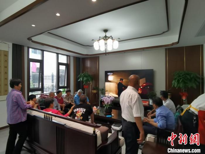 親友們集中在費(fèi)俊龍家中觀看返程的視頻。　鐘升 攝