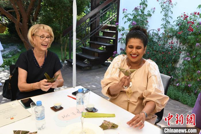 圖為嘉賓展示包粽子成果?！“亓种袊幕行墓﹫D。