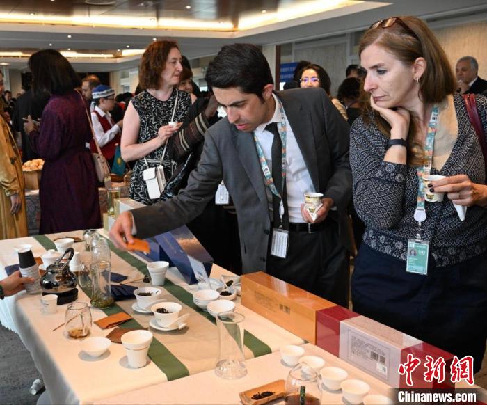 現(xiàn)場觀眾觀看中國展臺茶藝表演、了解茶文化。　靖樹 攝