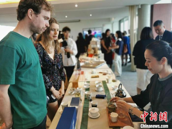 現(xiàn)場觀眾觀看中國展臺茶藝表演、了解茶文化。　靖樹 攝