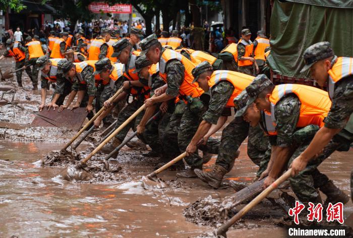 7月4日，萬州區(qū)五橋街道，武警官兵清理街道上的淤泥。　冉孟軍 攝
