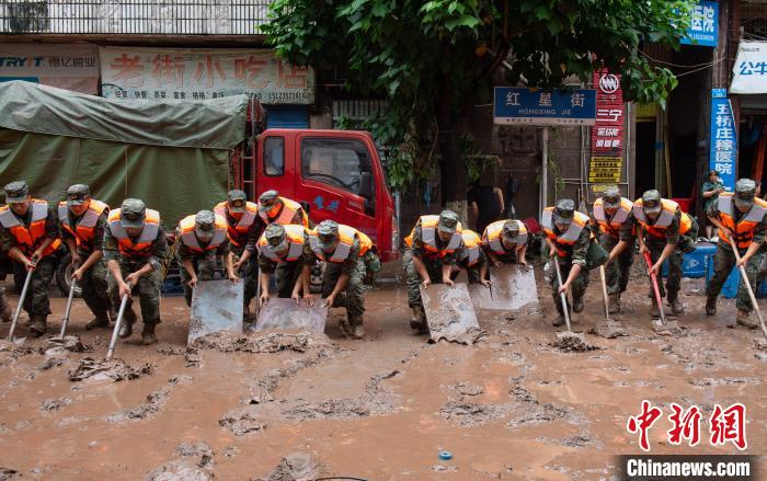 7月4日，萬州區(qū)五橋街道，武警官兵清理街道上的淤泥。　冉孟軍 攝