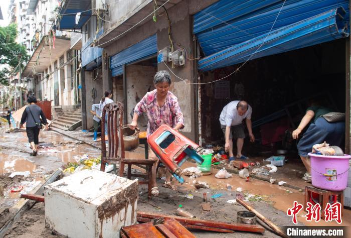 7月4日，萬州區(qū)五橋街道，洪水退去后，居民搶救生活物資?！∪矫宪?攝