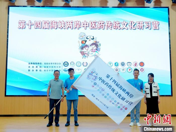 共青團福建省委副書記吳雪(右一)、福建中醫(yī)藥大學(xué)黨委副書記林羽(左一)為兩岸學(xué)生代表頒授營旗。　許燁婷 攝