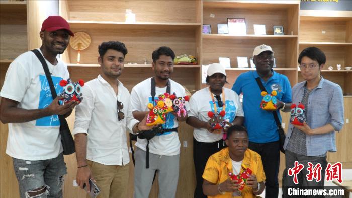 圖為國際青年代表展示親手制作的東營非遺黃河口布偶 。　齊魯 攝