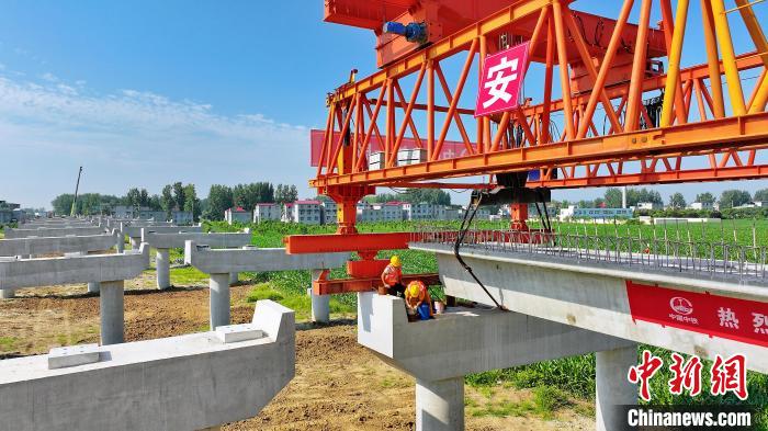 長25米重80噸的箱梁平穩(wěn)、精準地落在S314分離式立交橋25號和26號墩上?！⒂癫?攝