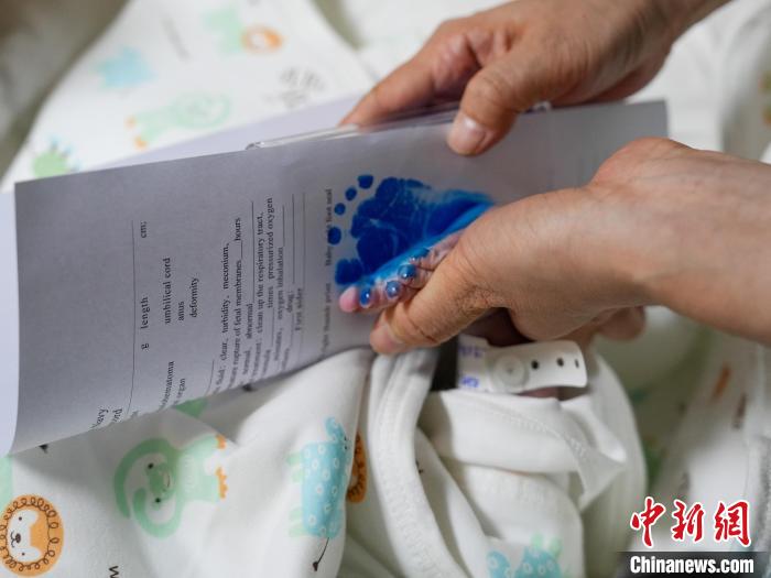 醫(yī)護人員為新生兒留下腳印。　劉偉 攝