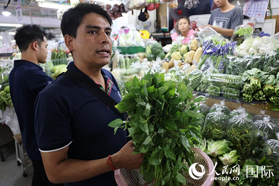 7月19日，泰國曼谷藍象餐廳員工向參加活動的多國代表介紹如何挑選新鮮蔬菜。 人民網(wǎng)記者 張矜若攝