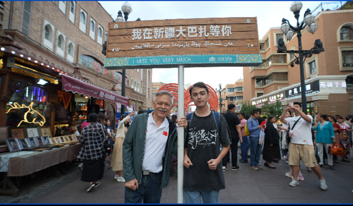 潘維廉和維吾爾族青年伊木蘭“打卡”大巴扎。主辦方供圖