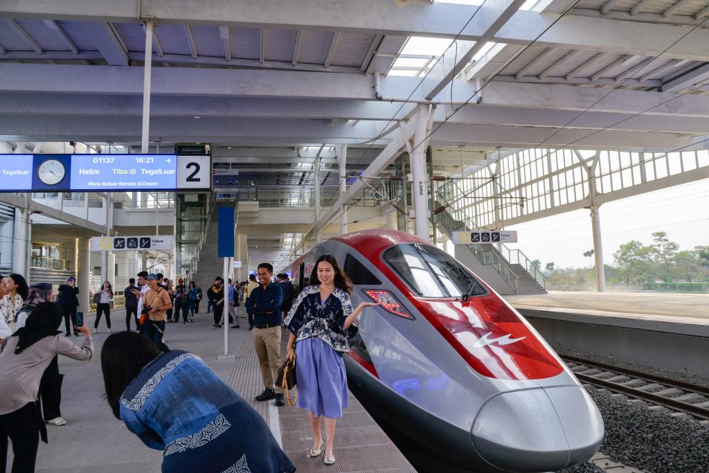 10月17日，在印度尼西亞萬隆德卡魯爾站，乘客在站臺上和雅萬高鐵高速動車組列車合影。