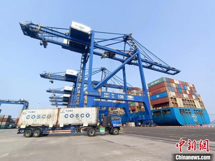 圖為海南洋浦國際集裝箱碼頭，卡車將集裝箱從后方堆場運往碼頭裝卸區(qū)?！堅潞?攝