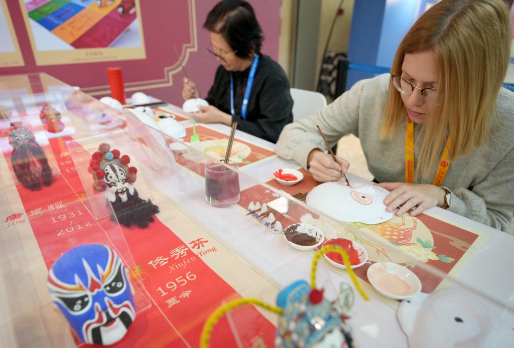 10月16日，在第三屆“一帶一路”國(guó)際合作高峰論壇新聞中心，來(lái)自比利時(shí)的記者（右）體驗(yàn)畫京劇臉譜。新華社記者 王毓國(guó) 攝