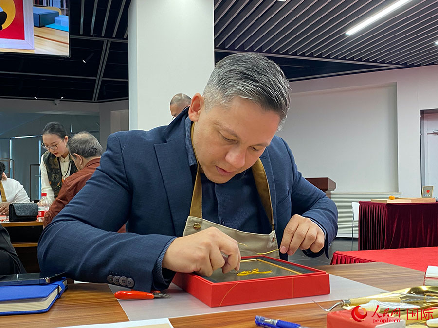 2023“一帶一路”媒體合作論壇聯(lián)合采訪團團員，親身體驗景泰藍工藝。人民網(wǎng)記者 于洋攝