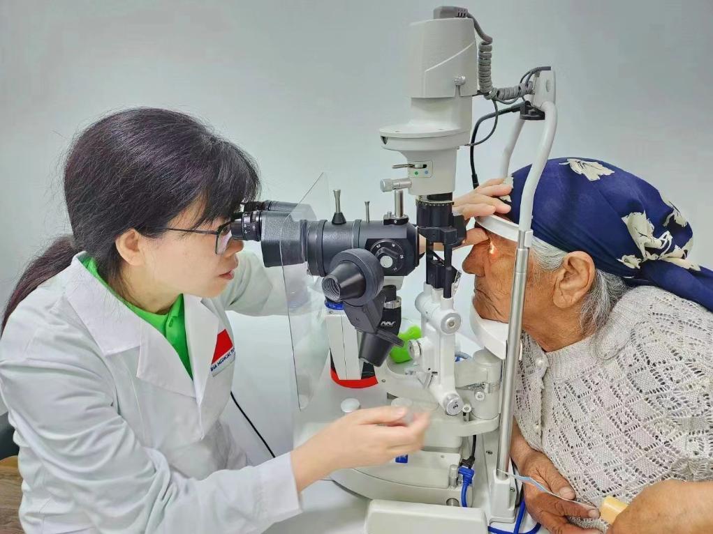 北京大學(xué)人民醫(yī)院眼科醫(yī)生鮑永珍正在為中亞白內(nèi)障患者進(jìn)行眼部檢查。（北京大學(xué)人民醫(yī)院供圖）