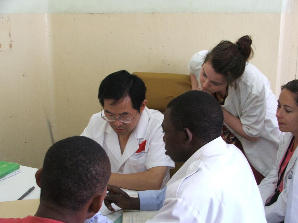 2011年7月22日，在坦桑尼亞桑給巴爾納茲莫加醫(yī)院外科門診，中國(guó)第24批援桑給巴爾醫(yī)療隊(duì)隊(duì)長(zhǎng)盧建林為當(dāng)?shù)鼗颊咴\治并帶教實(shí)習(xí)生。新華社發(fā)（國(guó)家衛(wèi)生健康委供圖）