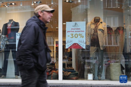   10月31日，一名男子從比利時布魯塞爾一家貼有打折信息的店鋪前走過。新華社記者 趙丁喆 攝