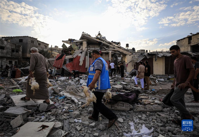 10月27日，在加沙地帶南部城市汗尤尼斯，人們經(jīng)過(guò)以軍襲擊后的房屋廢墟。