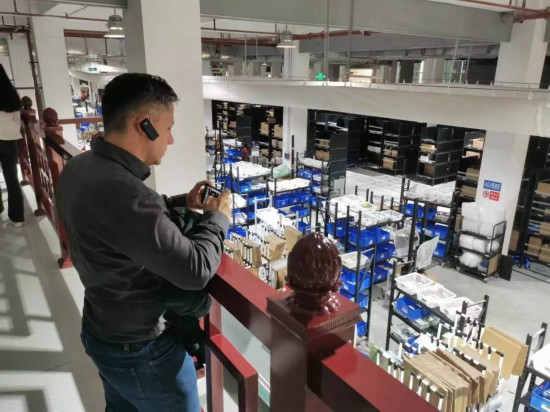 2023“一帶一路”媒體合作論壇聯(lián)合采訪團(tuán)團(tuán)員在仁和醫(yī)藥物流園拍攝記錄轉(zhuǎn)運(yùn)流程。（本報記者 黃超攝）