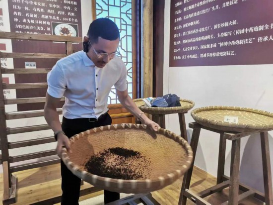 2023“一帶一路”媒體合作論壇聯(lián)合采訪團(tuán)團(tuán)員在非遺文化展示館體驗中藥炮制技藝。（本報記者 黃超攝）