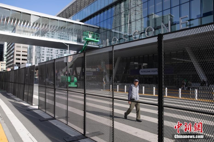 當(dāng)?shù)貢r間11月10日，一名行人從美國舊金山莫斯康中心周圍的金屬圍欄旁經(jīng)過。隨著亞太經(jīng)合組織(APEC)第三十次領(lǐng)導(dǎo)人非正式會議臨近，作為會議場地的莫斯康中心附近出現(xiàn)金屬圍欄，執(zhí)勤警察也大幅增加。<a target='_blank' href='/'><p  align=