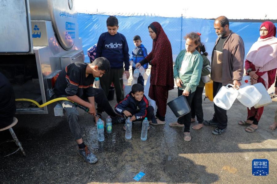 12月8日，在加沙地帶南部城市拉法一處臨時營地內，人們排隊打水。新華社發(fā)（里澤克·阿卜杜勒賈瓦德 攝）