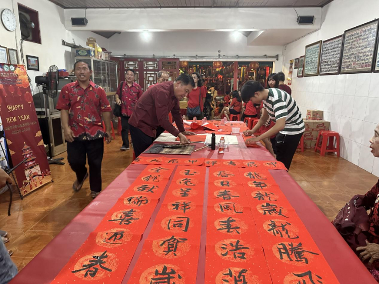 茍皓東為華人朋友現(xiàn)場寫春聯(lián)送福字。巴陵康孔子學(xué)院供圖