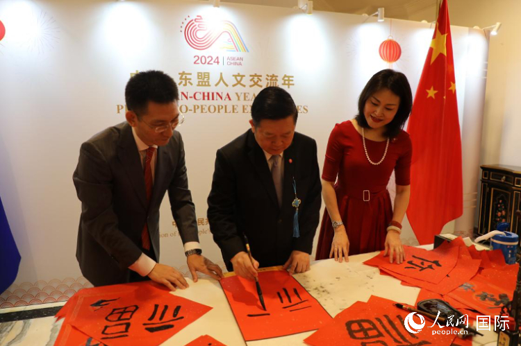 東盟秘書長高金洪（中）在活動現(xiàn)場寫福字。人民網(wǎng)記者曹師韻攝