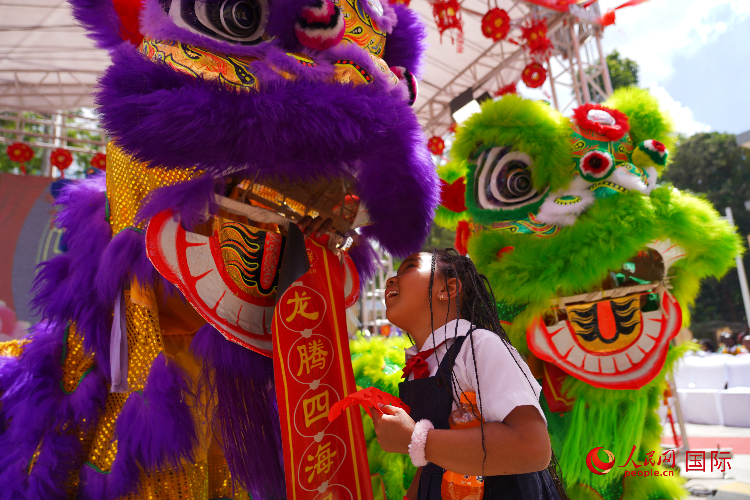 小朋友與舞獅表演者互動(dòng)。人民網(wǎng)記者 黃煒鑫攝