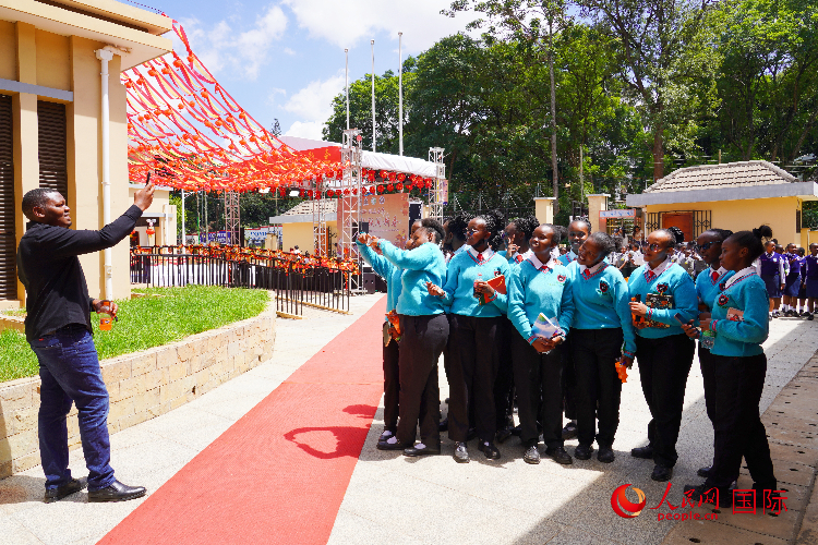 一名老師在給學(xué)生拍照留念。人民網(wǎng)記者 黃煒鑫攝