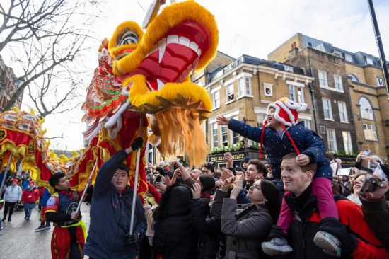 2月11日，人們在英國倫敦的新春巡游活動中觀看舞龍表演。新華社發(fā)（史蒂芬·程攝）