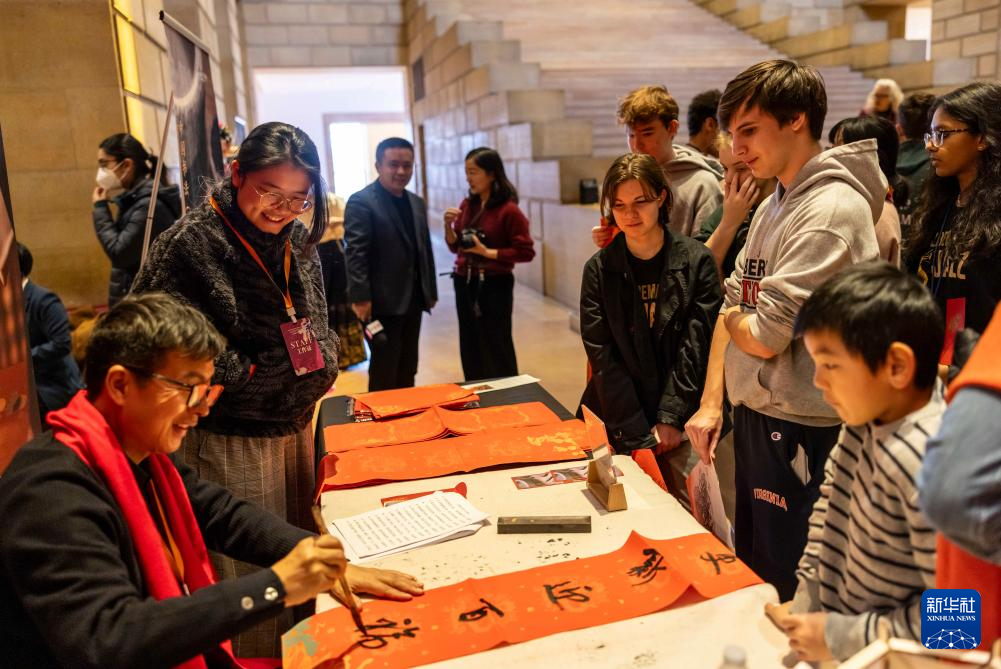 2月11日，書法家在美國費(fèi)城藝術(shù)博物館舉行的龍年迎新春活動上為參觀者書寫對聯(lián)。新華社發(fā)（周煥新攝）