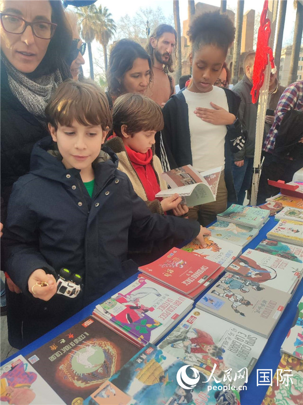 印刷精美的中國傳統(tǒng)文化叢書吸引了小游客的注意。人民網(wǎng)記者鄭彬攝