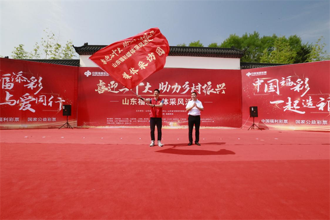 為媒體采風(fēng)團(tuán)授旗。 山東省福彩供圖