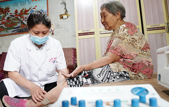 護(hù)理團(tuán)隊醫(yī)生為老人進(jìn)行低頻功能康復(fù)。陳佳兵攝