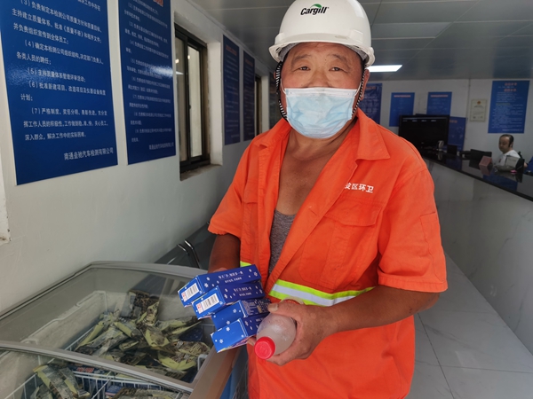 1環(huán)衛(wèi)工倪建宏小憩后，為還同事帶去冷飲。人民網(wǎng)記者王繼亮攝