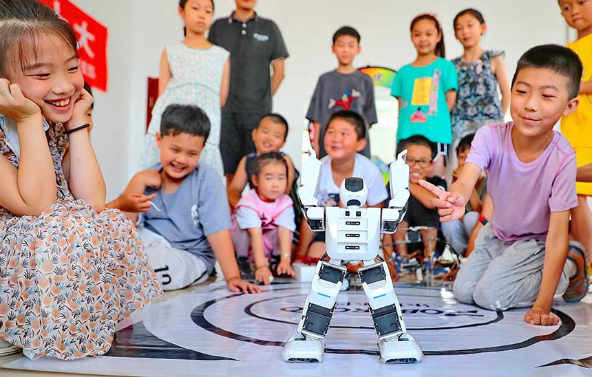 2022年7月19日，河北省秦皇島市海港區(qū)白塔嶺街道秦皇半島第二社區(qū)內(nèi)，小朋友正在觀看“機(jī)器人跳舞”。 曹建雄攝