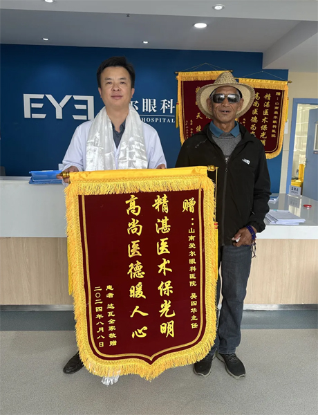 達(dá)瓦老人向吳四華（左）贈(zèng)送錦旗。受訪者供圖