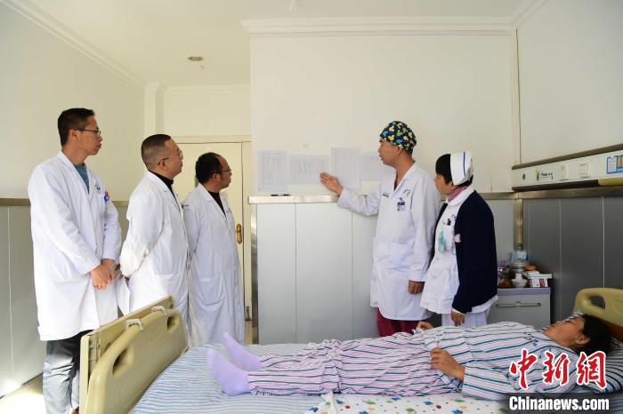 圖為何蔚副主任醫(yī)師(站右二)及團(tuán)隊(duì)術(shù)后對(duì)患者的肌肉訓(xùn)練、蛋白飲食等制定了每半日的康復(fù)計(jì)劃。　貢嘎來松 攝