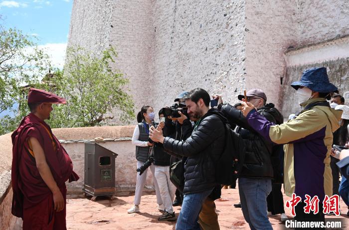 圖為中外媒體拍攝朝拜布達拉宮的僧人?！≮w朗 攝