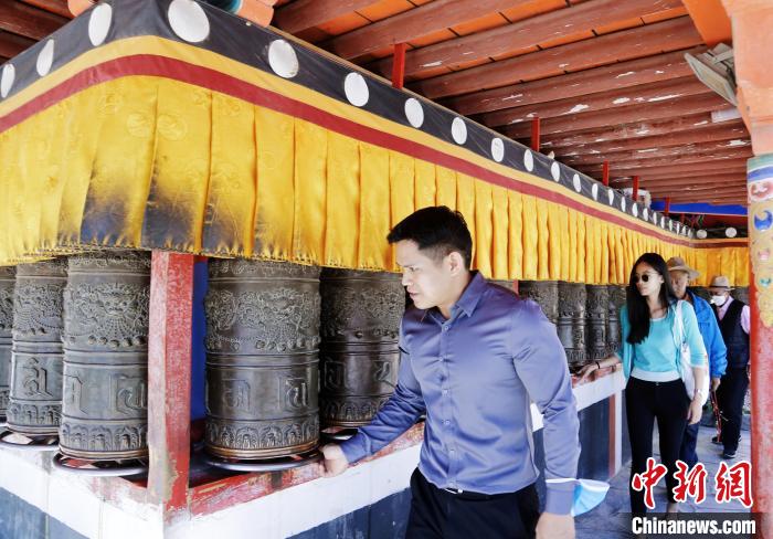 圖為外籍嘉賓體驗(yàn)藏族傳統(tǒng)轉(zhuǎn)經(jīng)筒?！●R銘言 攝