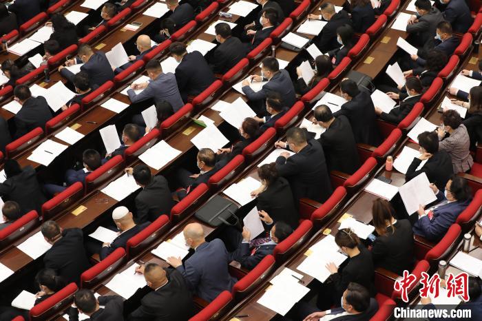 圖為會議現(xiàn)場，參會代表正在聽取政府工作報告?！∑钤鲚?攝