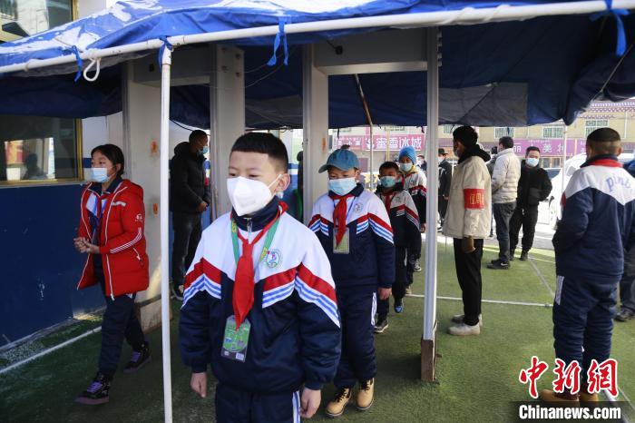 圖為學(xué)生測量體溫后進入校園。　馬銘言 攝