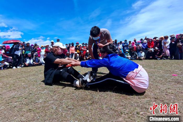 圖為當(dāng)?shù)孛癖娺M(jìn)行蹬棍比賽?！±铍h 攝