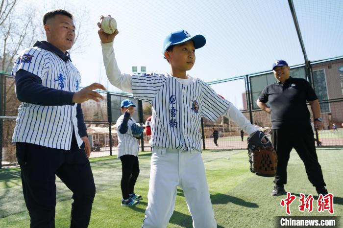 圖為教練指導(dǎo)小棒球手?jǐn)S球技術(shù)?！●R銘言 攝